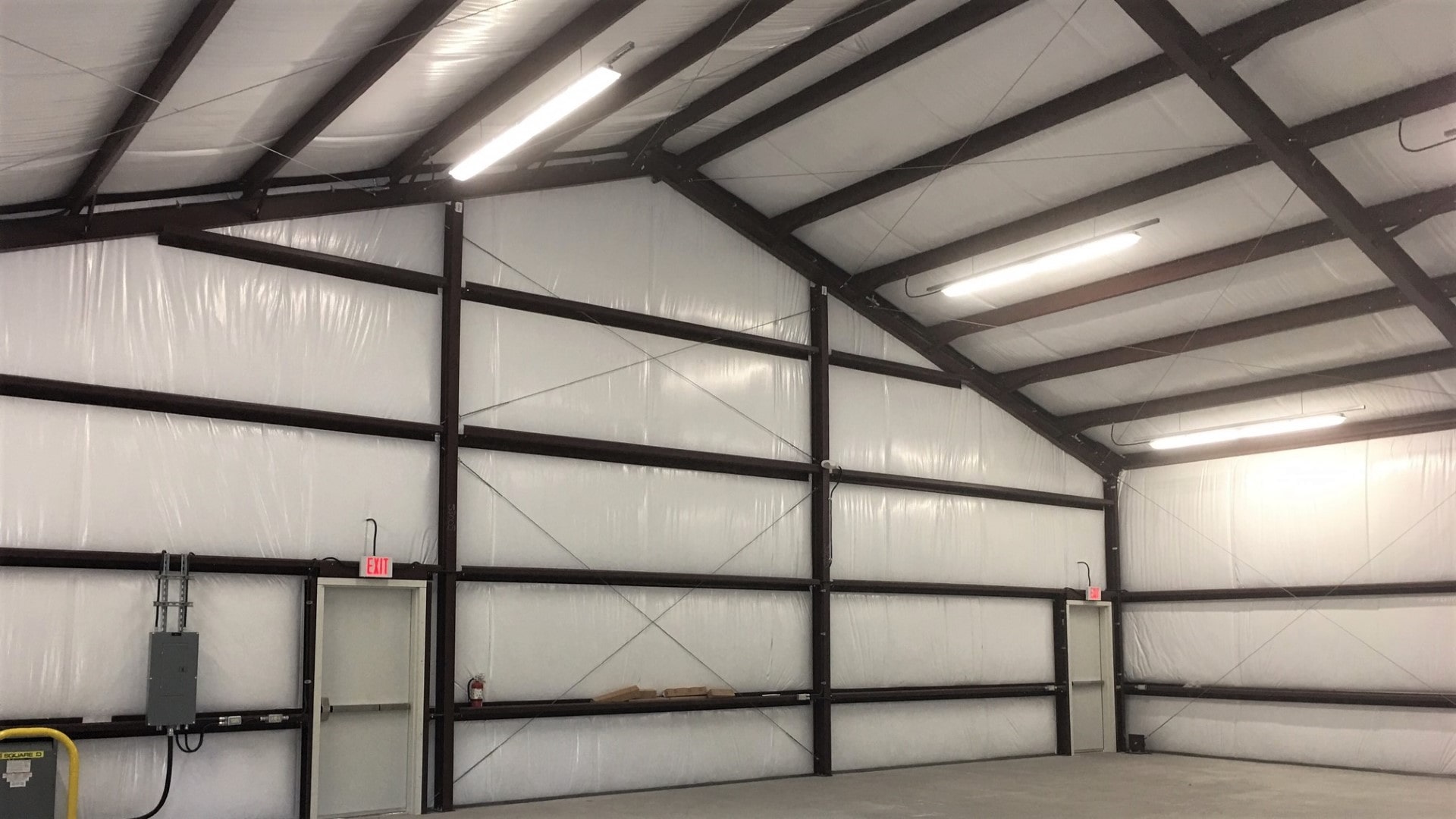 Faced fiberglass insulation installed inside a metal building to improve energy efficiency and control condensation.