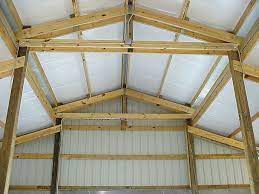 Faced fiberglass insulation installed in the walls of a pole barn or post-frame building to improve energy efficiency and comfort.