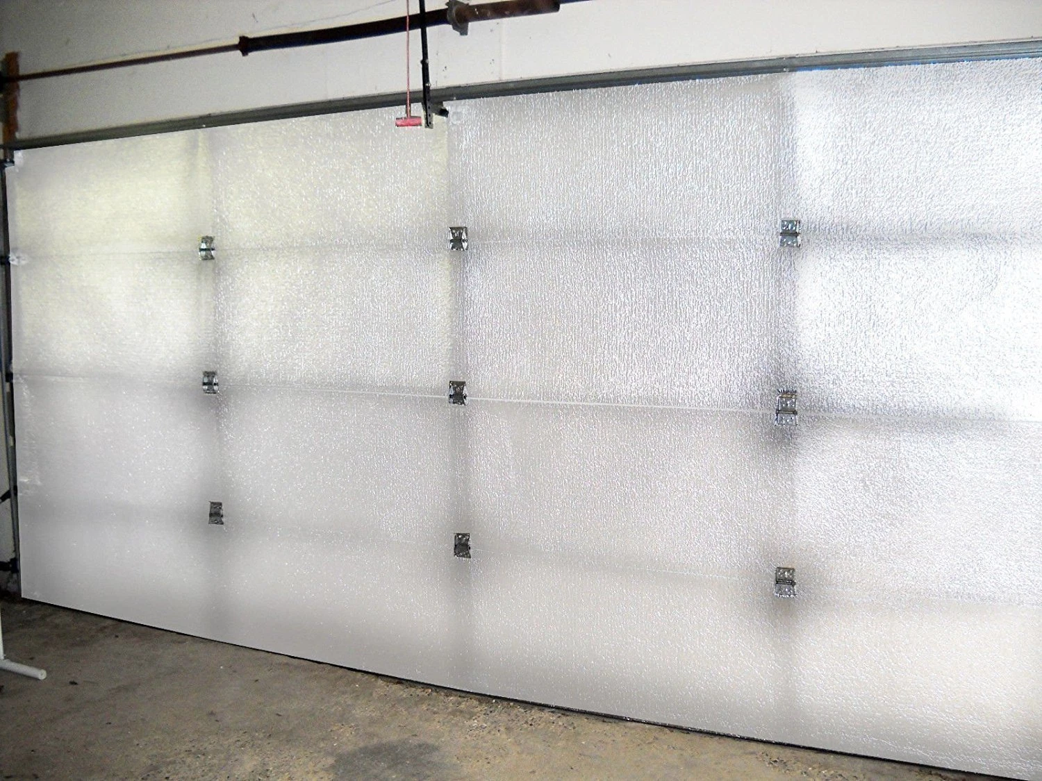 Garage door insulation kit with reflective foam panels reducing heat transfer and condensation